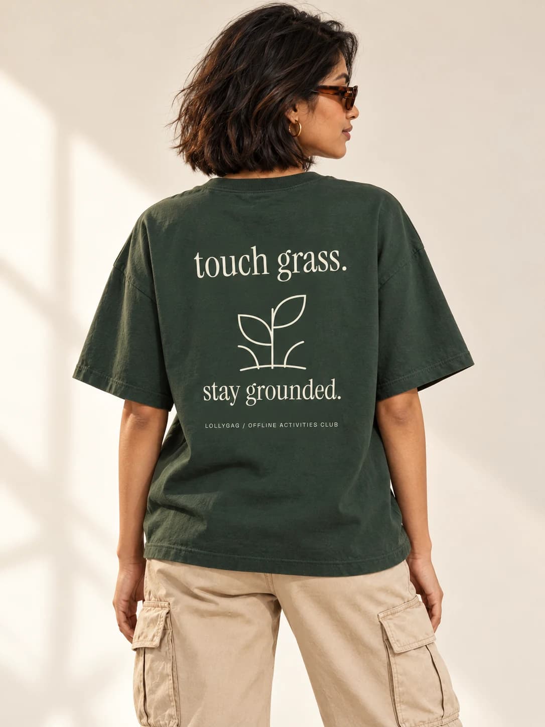 Touch grass botanical back print on a forest green oversized tee